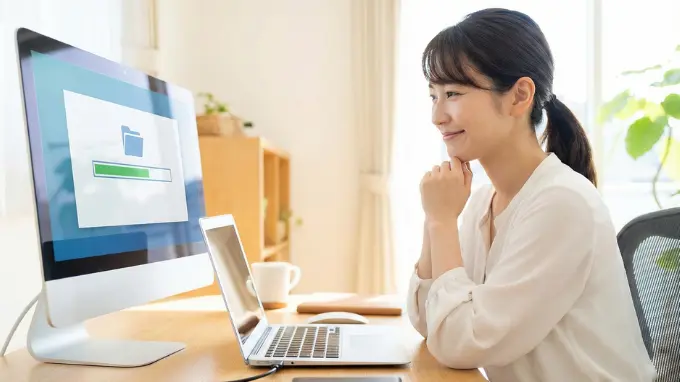 笑顔でパソコンを見る女性